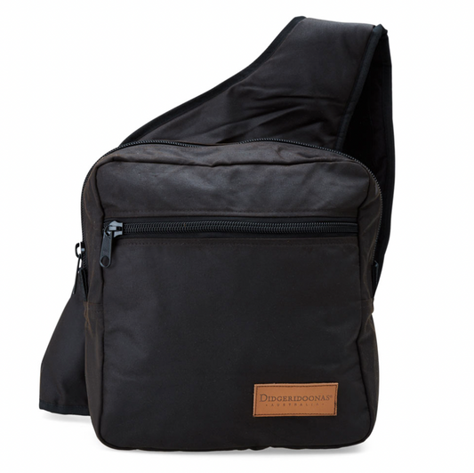 A black Australian oilskin riders bag with a single padded shoulder strap, two zippered pockets, and a phone pocket, designed for versatility and durability in various riding conditions.