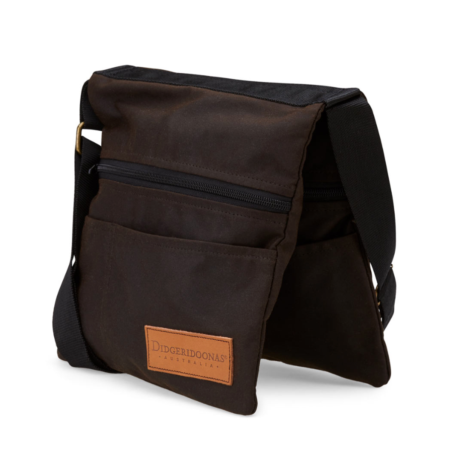 A dark brown canvas crossbody bag with a front zippered pocket and a tan leather brand patch