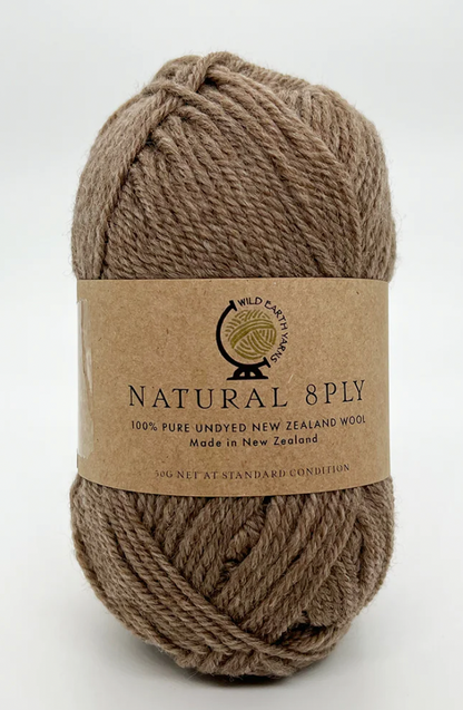 A skein of Natural 8 Ply undyed New Zealand wool in a walnut color, with a label displaying the brand and fiber content.