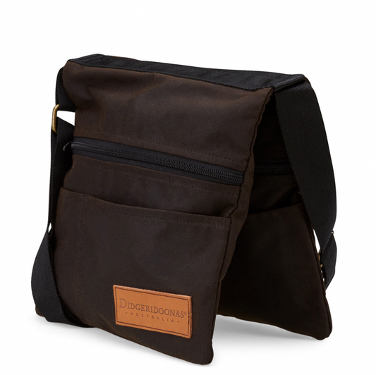 A brown Oilskin Shoulder Tote Bag with multiple pockets and an adjustable strap, displayed in an upright position with the brand label visible.