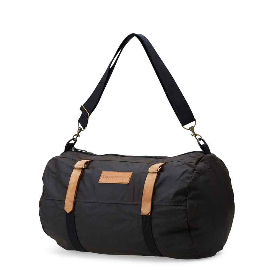 A black nylon duffel bag with tan leather strap accents and a black adjustable shoulder strap, shown on a plain white background.